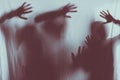 blurry scary silhouettes of people touching frosted glass with hands Royalty Free Stock Photo