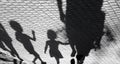 Blurry shadow of a little boy and a girl walking with adults