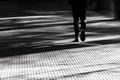 Blurry silhouette shadow of a person walking on a city arcade walkway