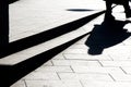 Blurry silhouette shadow of a person walking on a city sidewalk with steps in black and white Royalty Free Stock Photo
