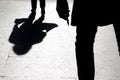 Blurry silhouette and shadow of a woman carrying a bag and a man