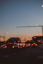 Blurry silhouette of a traffic light on a busy street in a city at dusk