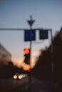 Blurry silhouette of a traffic light on a street in a city at dusk