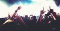 Blurry of silhouettes of concert crowd at Rear view of festival crowd raising their hands on bright stage lights Royalty Free Stock Photo