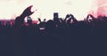 Blurry of silhouettes of concert crowd at Rear view of festival crowd raising their hands on bright stage lights Royalty Free Stock Photo