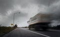 Blurry speed truck running through sharp curve with arrow warning signs.