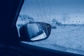 Blurry wet abstract glass background. Rear back view car mirror with rain drops during rainy bad weather. Sadness loneliness Royalty Free Stock Photo