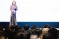 Blurry of woman speaker speech on stage in auditorium for shareholders` meeting Royalty Free Stock Photo