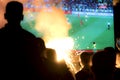 Blurry young football fans watching football match on the street