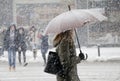 Blurry young women walking under umbrella in heavy snowfall