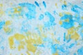 Blury image of blue and yellow handprints on a white wooden wall. Colorful background. Royalty Free Stock Photo