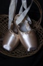 Blush ballet Pointe shoes in wood basket with moody feel