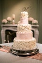 Blush and Cream Wedding Cake in front of a fireplace