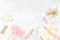 Blush and gold feminine desktop with makeup and keyboard. Copy sp