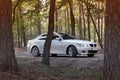 Kiev, Ukraine - September 9, 2018. BMW E60 on the forest road. A car with lights on in the forest Royalty Free Stock Photo