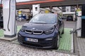 BMW i3 electric car is being charged from an electric charging station, charging cable, another gas station for traditional