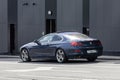 BMW 640i F13 parked on the city street. Dark blue BMW 6 Series coupe car, rear side view Royalty Free Stock Photo