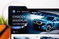 BMW Logo under a magnifying glass. BMW Website on Laptop screen