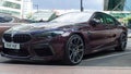 BMW M8 Competition Gran Coupe in Ametrin metallic color parked on the city street. Front side view of 4-door fastback sedan