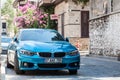 BMW 3 Series F30 car moving on the street. Blue turquoise sedan BMW on the parking, front side view