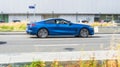 BMW 8 Series G15 car on the road in motion. Fast speed drive on city road. Side view of moving blue coupe BMW 840d on the street