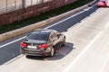 BMW 5 series on the road in motion. Fast speed drive on city road, zenith aerial view