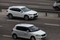 BMW white rides on the road. Against a background of blurred trees