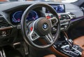 BMW X3 M Competition steering wheel and dashboard. Beige leather car interior.