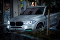 BMW X3 SUV car driving through the city at night