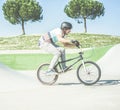 Bmx biker getting ready for jumping in city skate park outdoor - Young trendy man performing skills and tricks with special Royalty Free Stock Photo