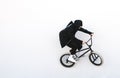 Bmx cyclist in dark clothes rides on a white background. Bike rider on bmx bike isolated on white background