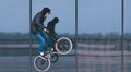 BMX freestyle. man doing tricks on BMX against a dark shop window. Street culture Royalty Free Stock Photo