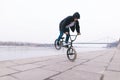 BMX freestyle. A young man is doing tricks on a BMX bike near the river Royalty Free Stock Photo