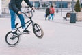 BMX freestyle. Young man doing tricks in a park on a BMX bike. The cyclist trains on the back wheel of the bike Royalty Free Stock Photo