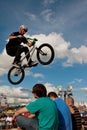 BMX Rider Performs Stunt Over Three Audience Members At Fair