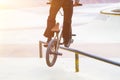 bmx rider in skate park practicing tricks sliding on frame of bike on ramp Royalty Free Stock Photo