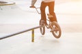 bmx rider in skate park practicing tricks sliding on frame of bike on ramp Royalty Free Stock Photo