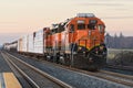 BNSF diesel locomotive with mixed freight train at in evening light