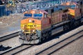 A BNSF diesel locomotive pulls multiple BNSF motive power in various historical color schemes showing years of mergers