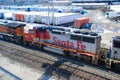 A BNSF diesel locomotive pulls multiple BNSF motive power in various historical color schemes showing years of mergers