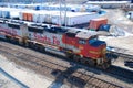 A BNSF diesel locomotive pulls multiple BNSF motive power in various historical color schemes showing years of mergers