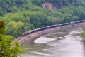 BNSF train engine pulling a string of tank cars along the Mississippi river