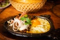 Bo ne trung, beef cooked in a hot plate with gravy, eggs and corn which is a westernized vietnamese breakfast