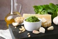 Board with bowl of pesto sauce and ingredients. Space for text Royalty Free Stock Photo