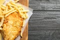 Board with British traditional fish and potato chips on wooden background, top view. Royalty Free Stock Photo