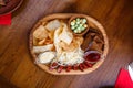 Board with chips, sausages, rye bread, cheese and red and white sauce. On a wooden table Royalty Free Stock Photo