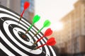 Board with color darts hitting target against blurred view of cityscape Royalty Free Stock Photo