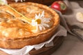 Board with delicious apple pie and flower on table, closeup Royalty Free Stock Photo