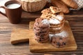 Board with delicious chocolate chip cookies on wooden table Royalty Free Stock Photo