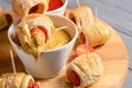 Board with delicious sausage rolls and bowl of sauce, closeup Royalty Free Stock Photo